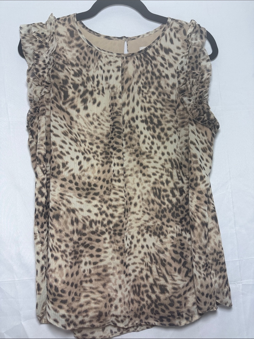 Leopard print lined sleeveless shell. Button neck and ruffle sleeve.